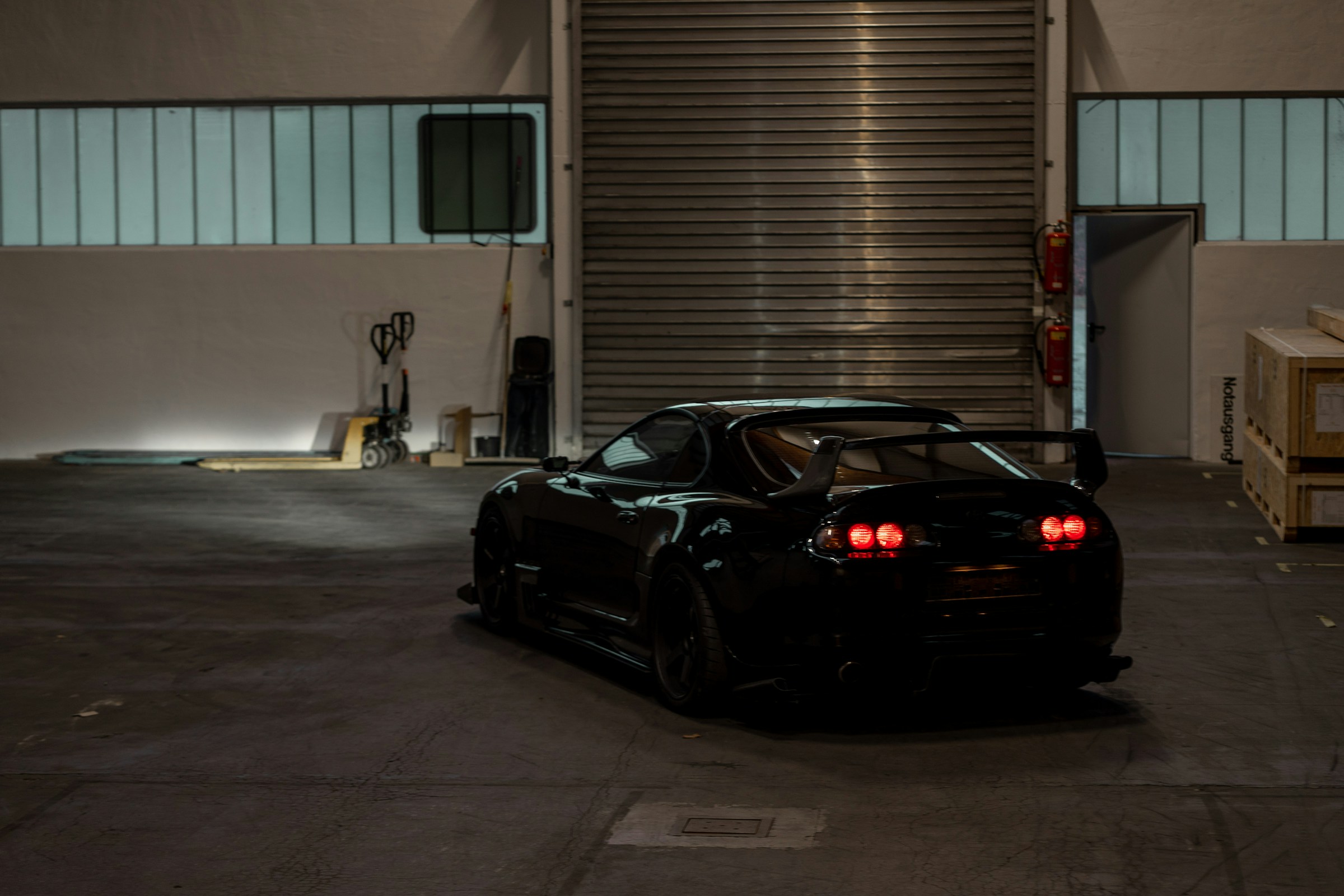 Black performance car parked in an industrial garage